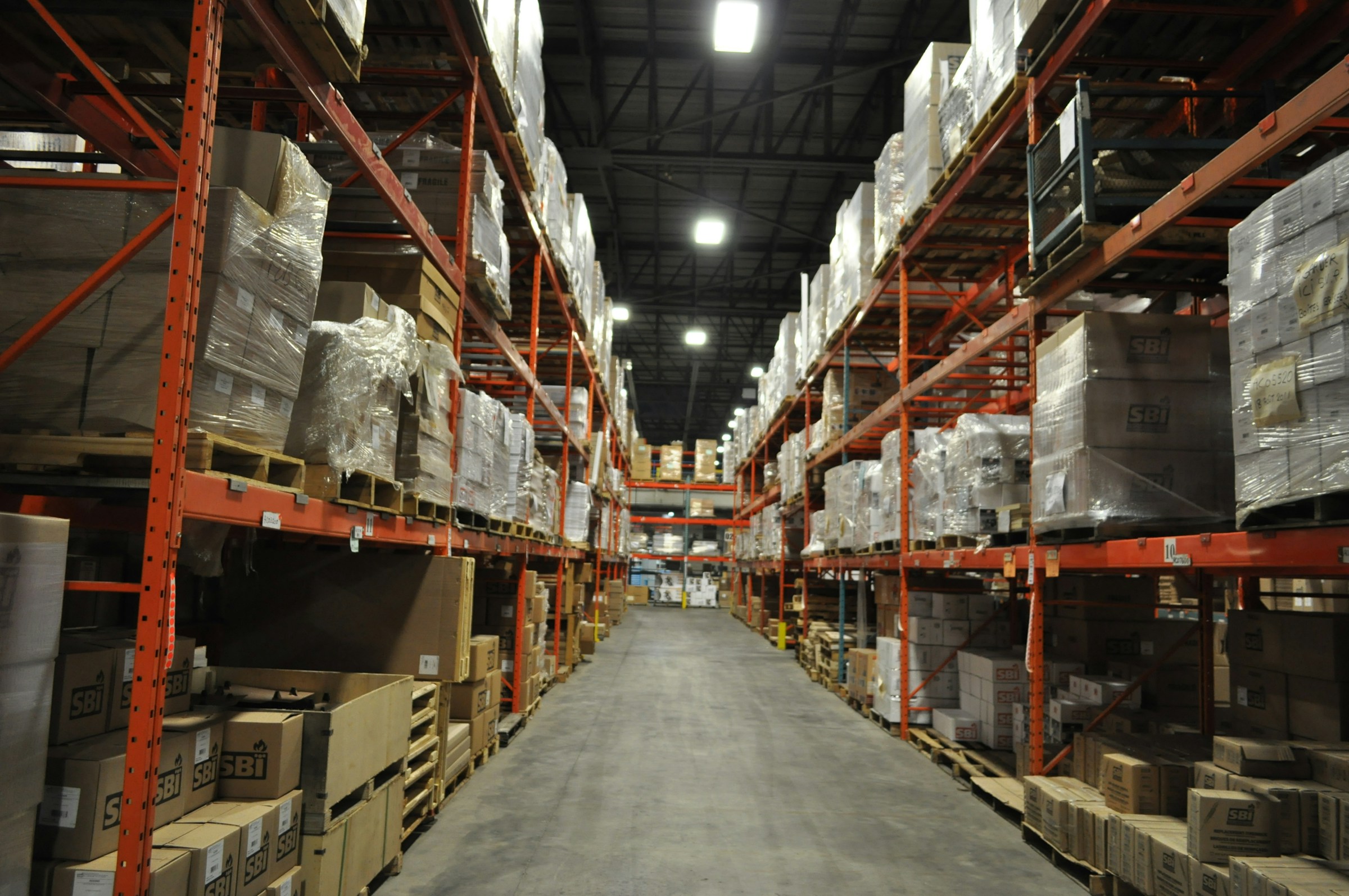 Tall warehouse shelves organized with pallets and packaged goods